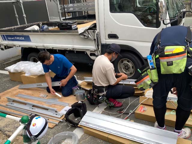 看板納品のための設置準備中のスタッフ達